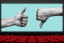 The interior of a movie theater with two hands showing a thumbs up and thumbs down on the screen