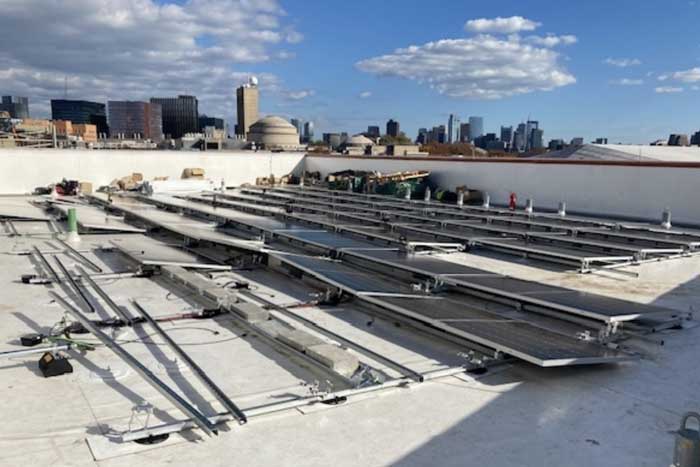 solar panels being installed on a roof, with Great Dome in background