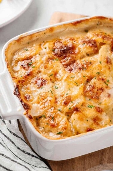 potatoes au gratin served in a square white casserole dish