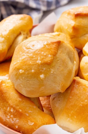 close up of parker house rolls topped with butter.