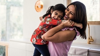 Mother and daughter smiling and hugging.