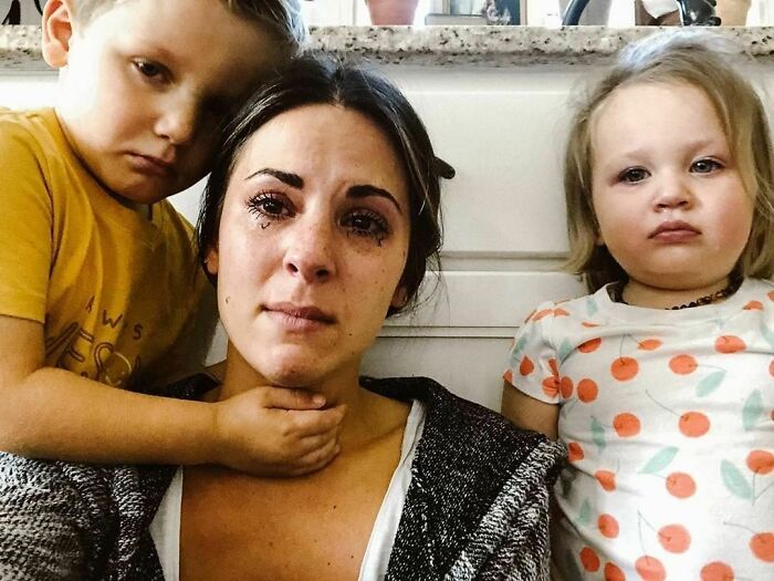 Woman with two children, expressing emotions in a real-life moment at home.