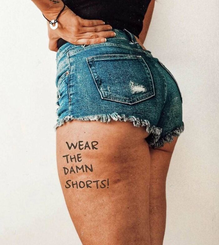 Woman wearing denim shorts with a message "Wear the damn shorts!" written on her thigh.