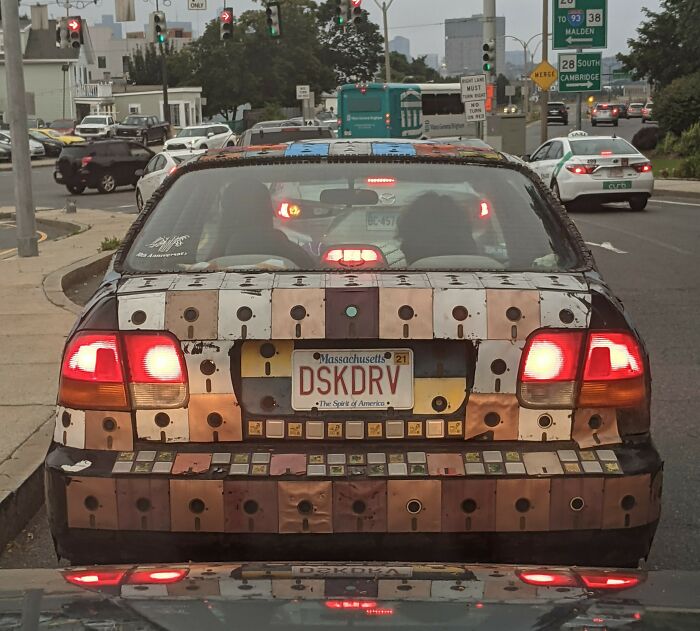 Car covered in colorful cassette tapes with a Massachusetts license plate, highlighting interesting things on the road.