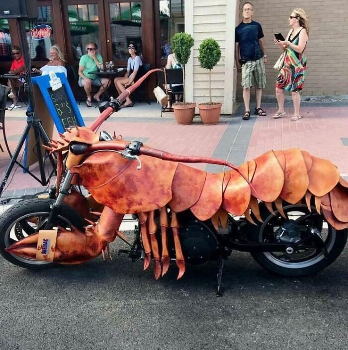 Unique lobster-themed motorcycle parked on a city street, capturing a humorous car-fails moment.