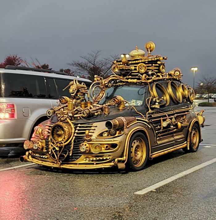 Steampunk-inspired car adorned with golden gears and gadgets in a parking lot, showcasing a creative car-fail design.