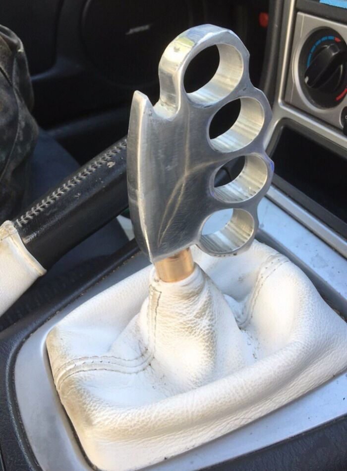 Unusual car gear shift shaped like brass knuckles, showcasing a car-fails modification.