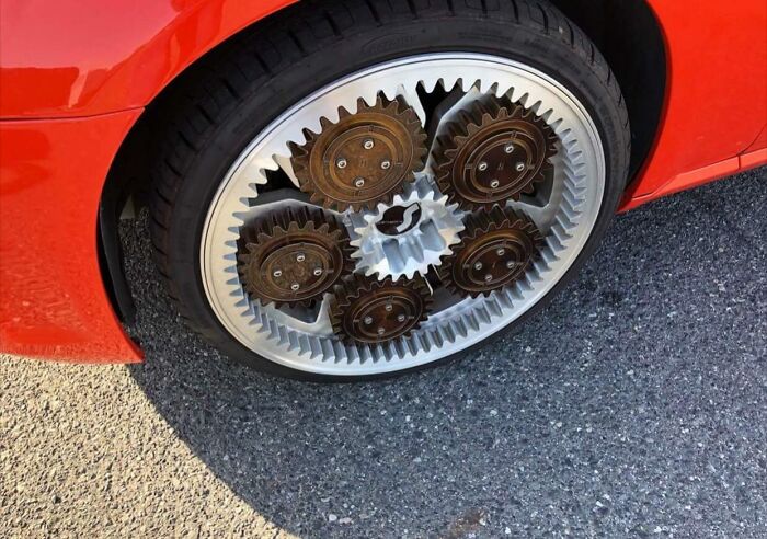 Close-up of a car wheel with gear-shaped rims, illustrating a unique car-fails design.