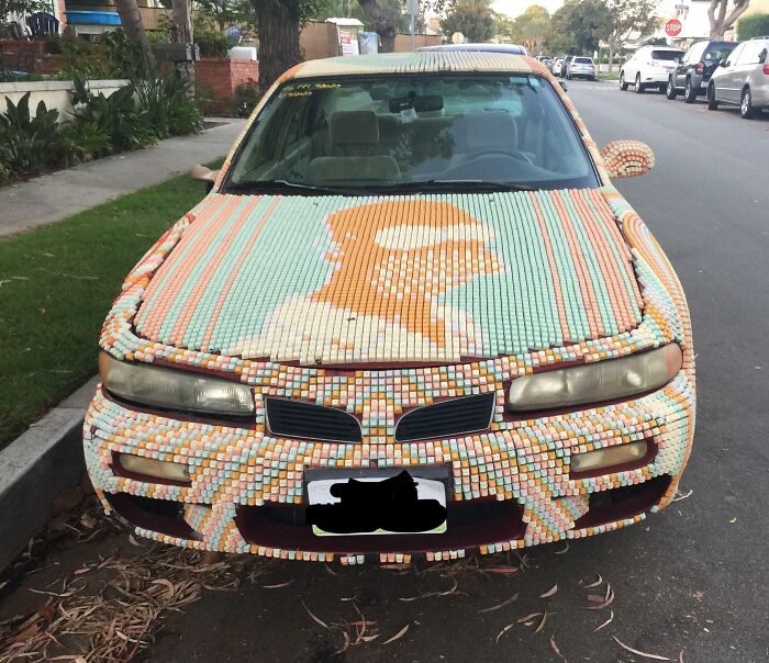 Decorative car with mosaic tile art on the hood, an example of car-fails in customization.