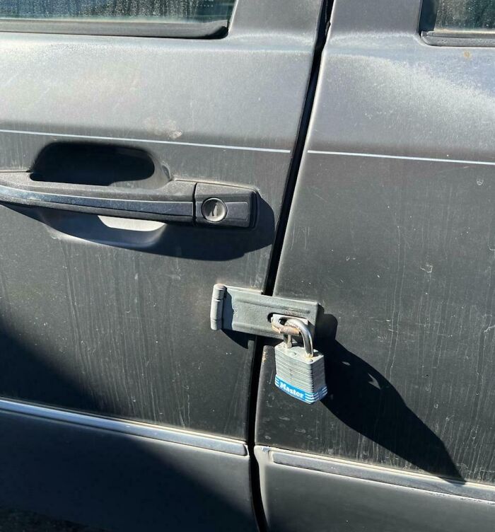 Car door secured with a padlock, highlighting a car-fail attempt at improvised security.