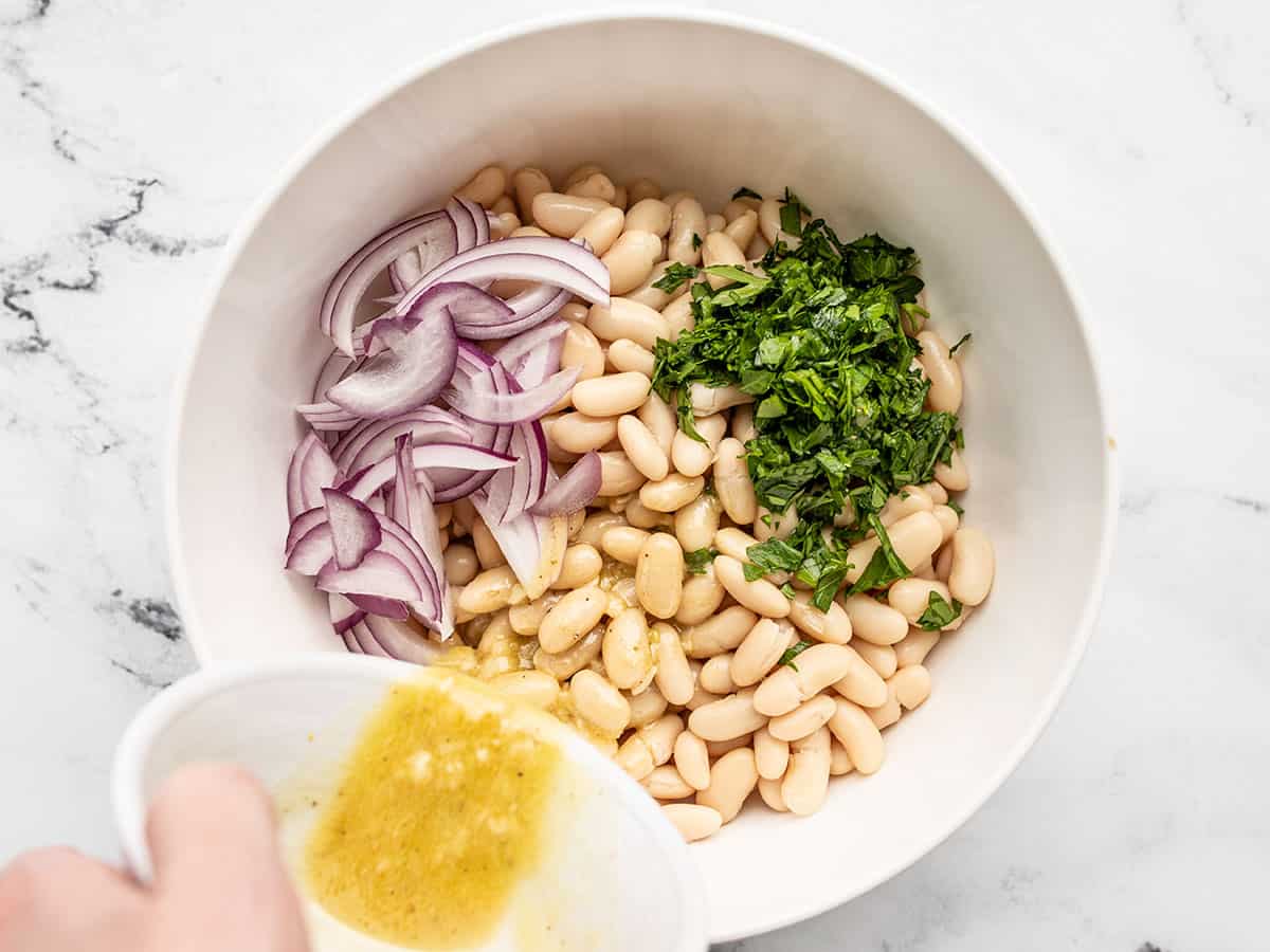 Salad ingredients being combined in a bowl.