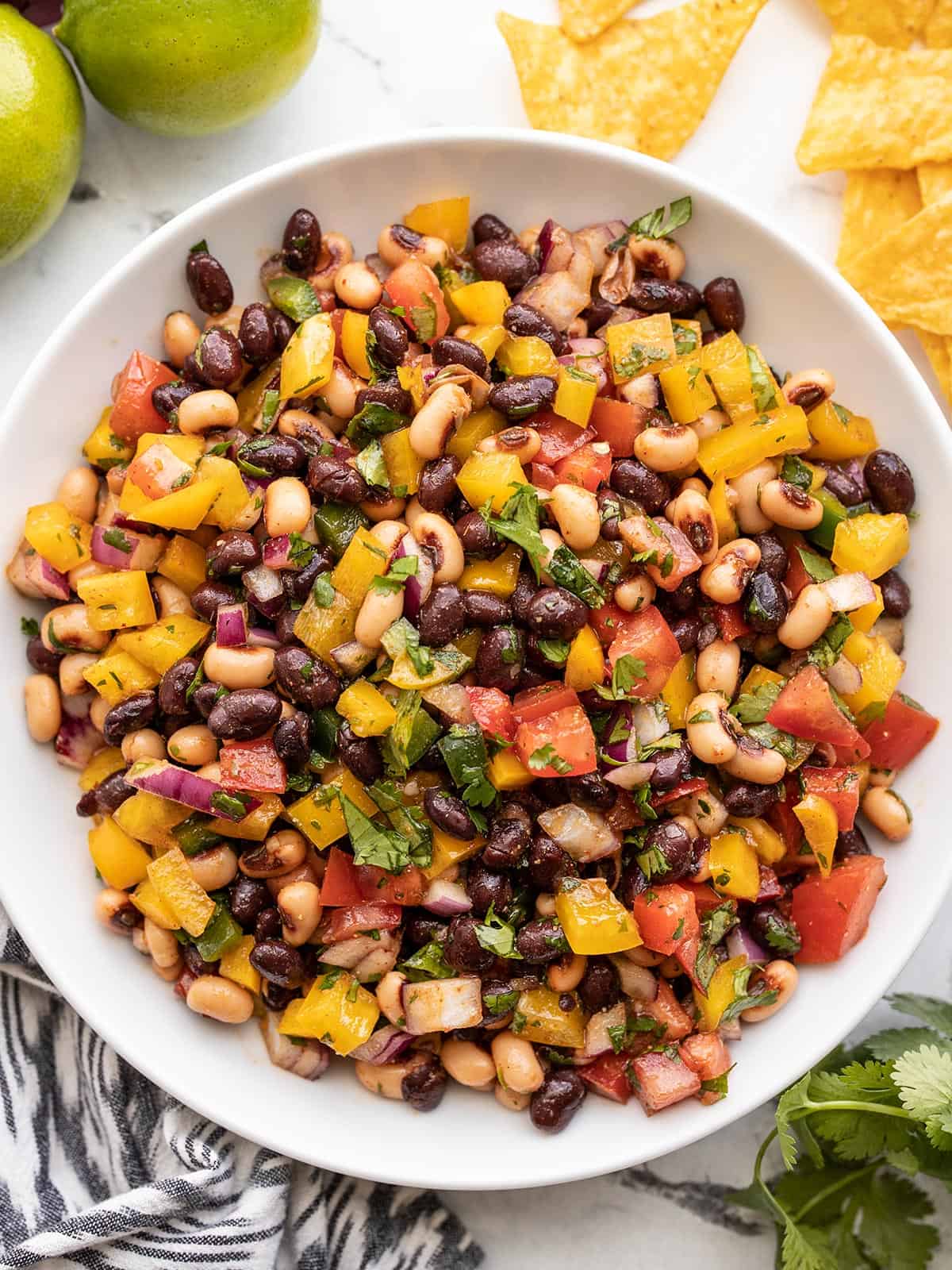 Close up overhead view of cowboy caviar in a bowl with chips on the side.