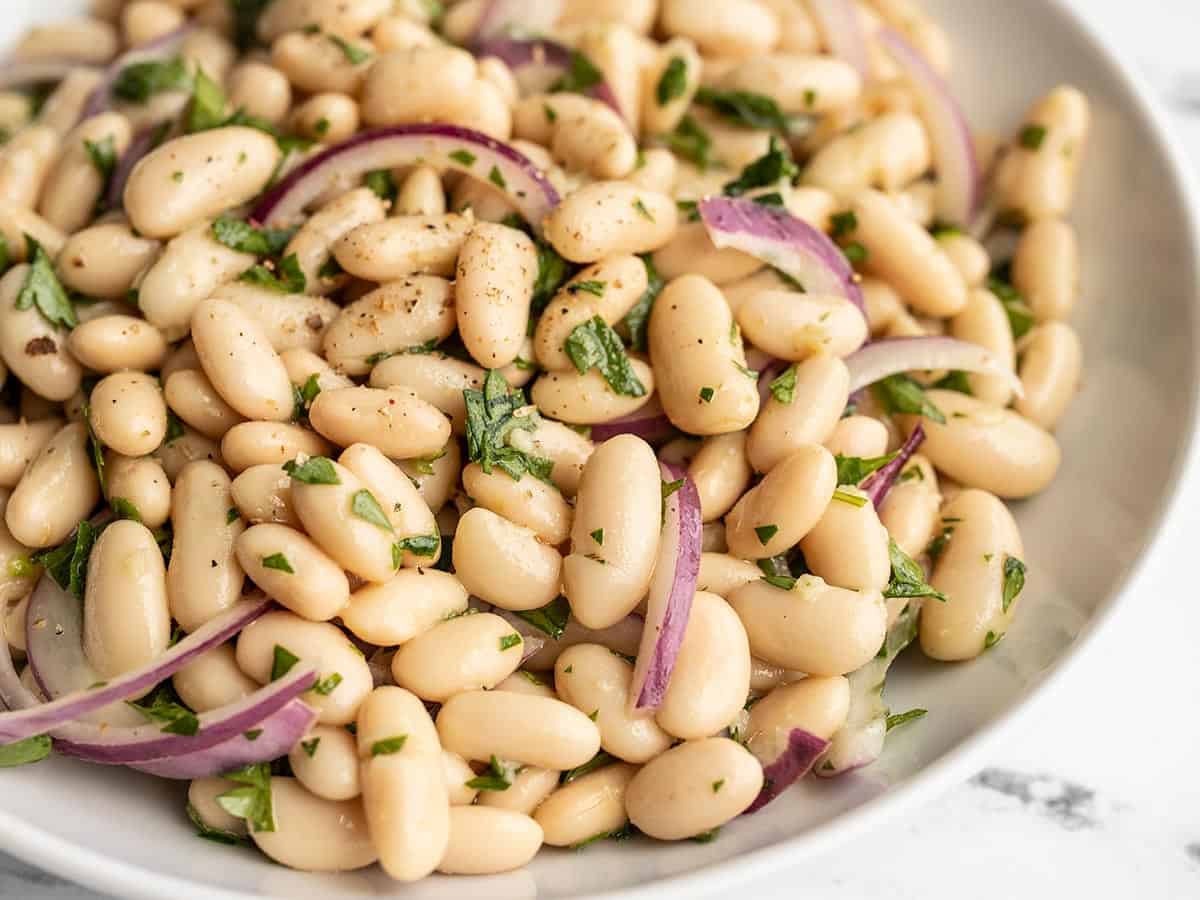 Close up side view of Lemony White Bean Salad in a bowl.