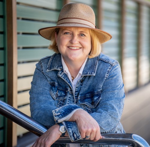 Cathryn Hein author wearing a blue denim jacket and a tan hat