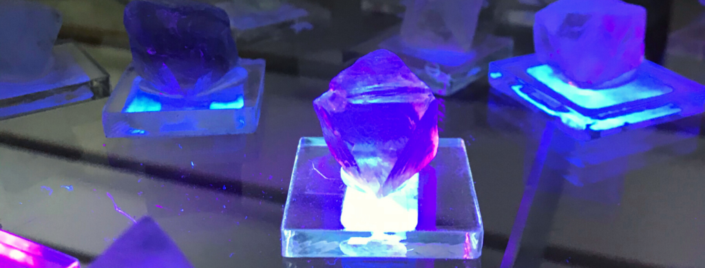 Photo of fluorite glowing under a blacklight