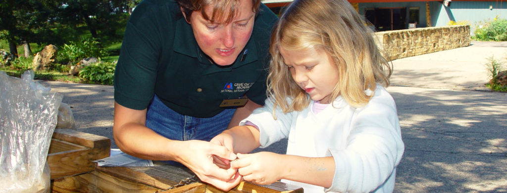 Photo of little girl sluicing sand to find crystals with a tour guide