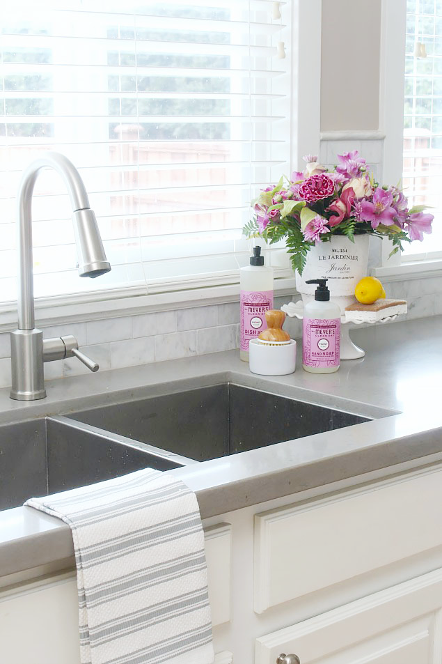 Farmhouse style organized kitchen with pretty sink display.