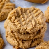 Peanut butter cookies on parchment paper with recipe title on top of image