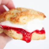 Holding Irish Scone with whipped cream and jam