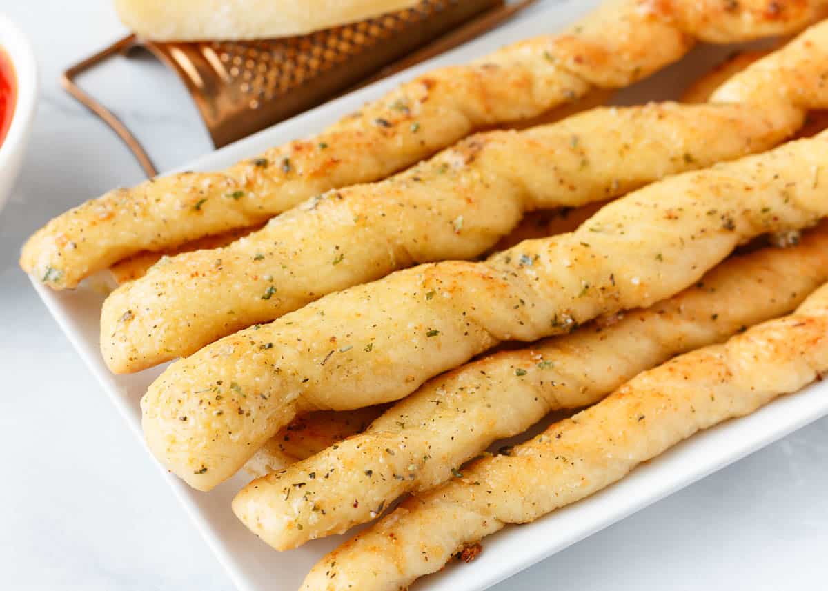 Easy homemade breadsticks on a white plate.