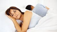 Man and woman lying in white linen bed