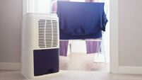 Dehumidifier working while drying laundry at home