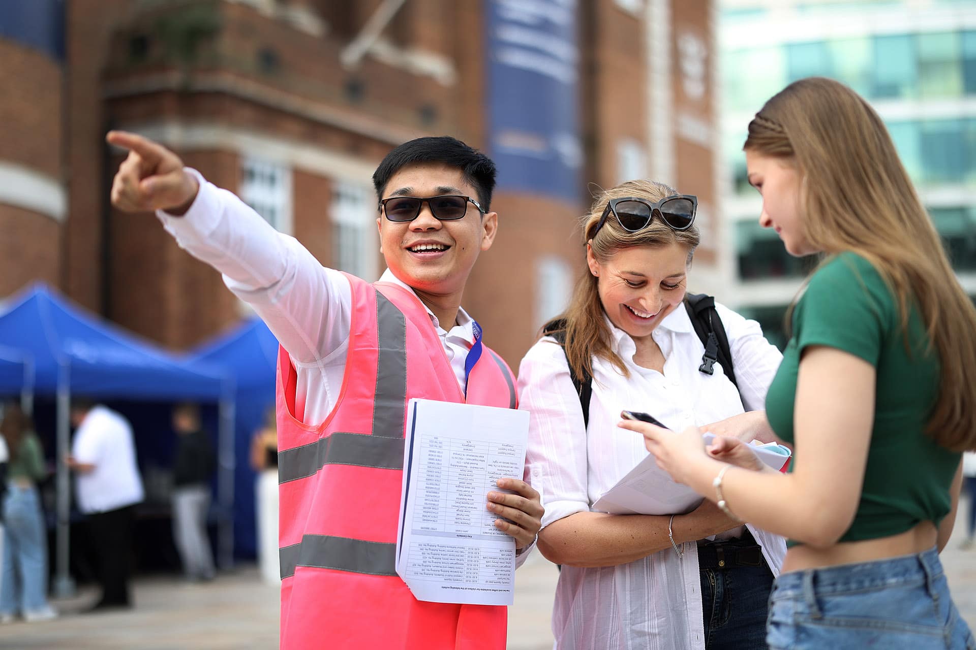 Staff member talking and pointing to direct people at Open Day