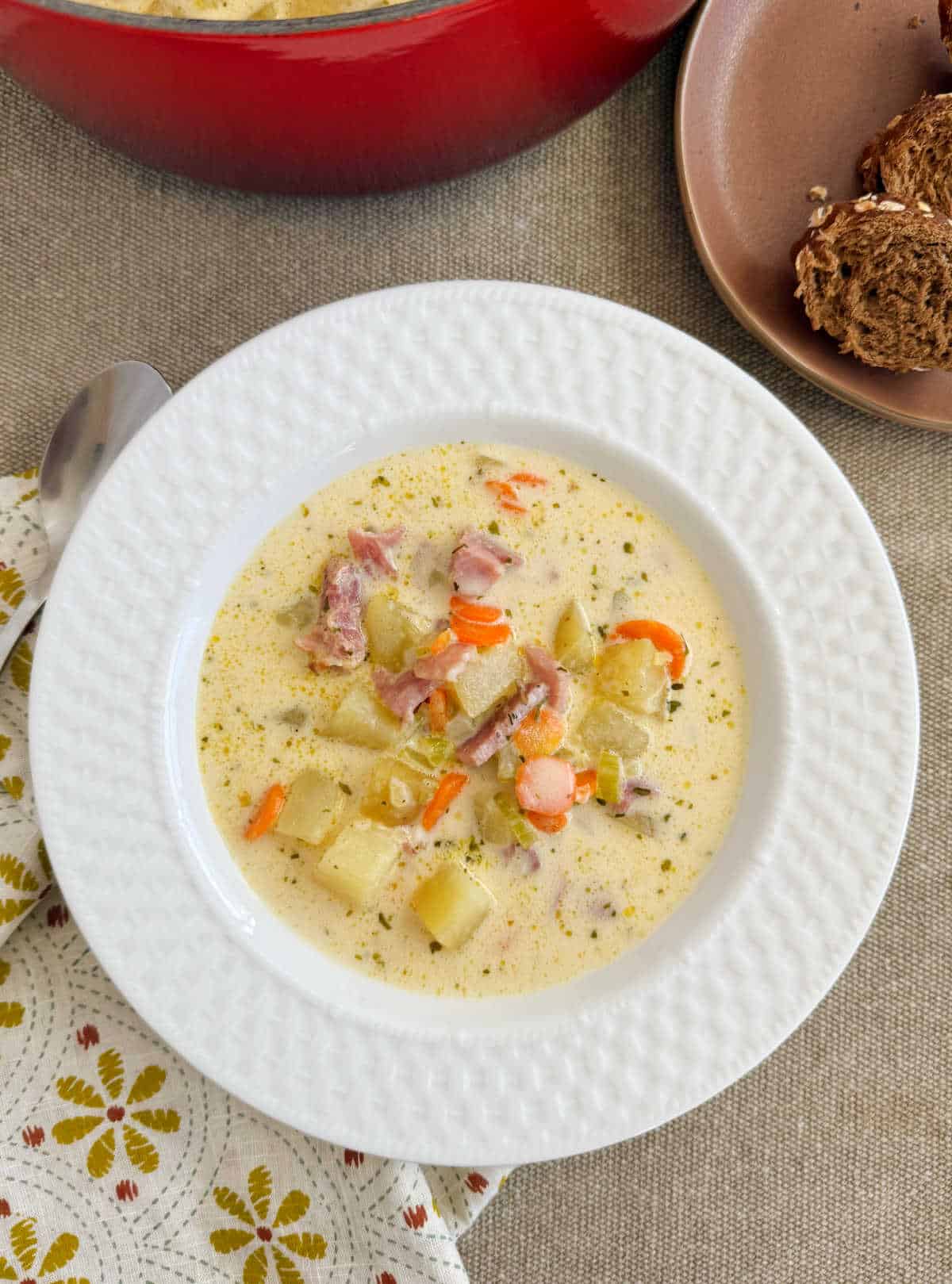 bowl of ham and potato soup with carrots.