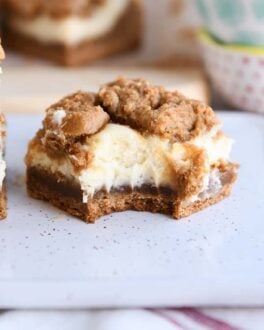 gingerbread cookie cheesecake bar with bite taken out on white tray