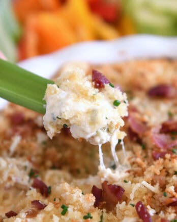 Creamy cheesy bacon dip on piece of celery.