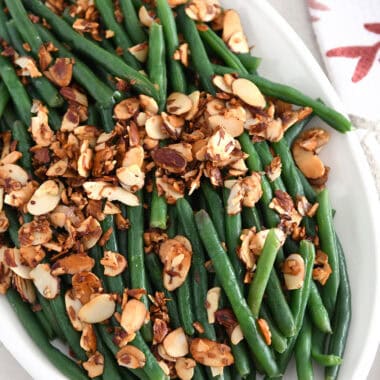 Top down view of steamed green beans with toasted almonds, garlic and shallots.