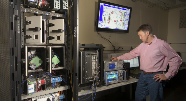 Male in pink shirt looking at scientific device