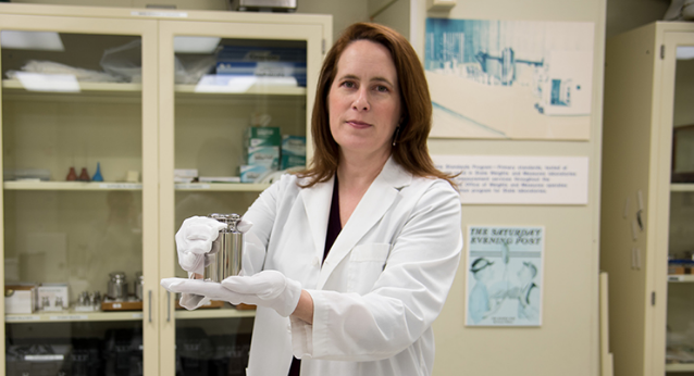 Women in white lab coat holding test tube 