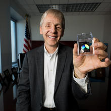 Man holding a NIST on a Chip device