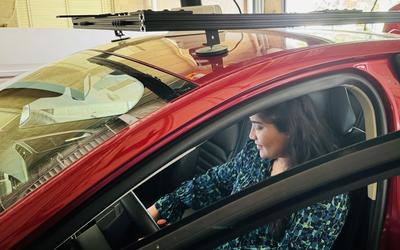 Mahima Arora sits in a red car that is outfitted with special equipment for autonomous vehicle testing.