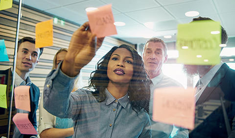 Your Turn photo showing a team of employees posting notes to a wall.