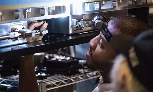 Asia Robertson of NIST’s Fabrication Technology Office makes final adjustments on an encasement.