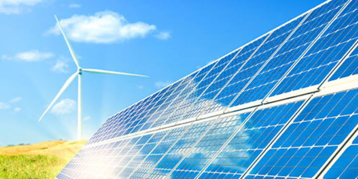 Blue sky. Green grass. Wind mill. To the right: solar panels