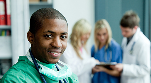 A physician looks while those behind him look at a chart. 