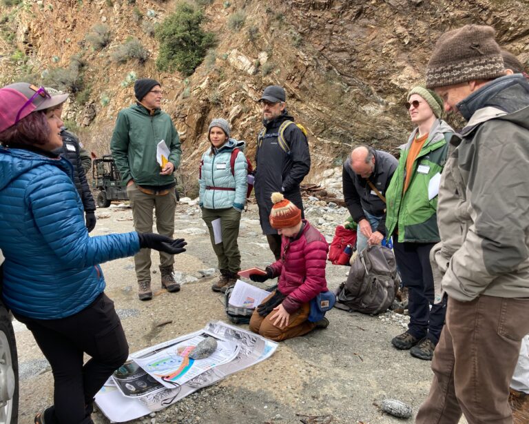 a group of SCEC scientists studying maps and images outside