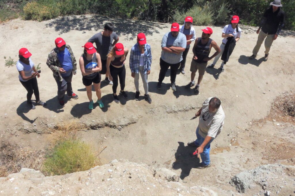 group of people wearing SCEC hats by rocks