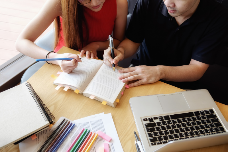 personas escribiendo en un cuaderno