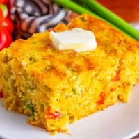 Close up looking at a slice of Mexican Cornbread with a pad of melting butter on top.