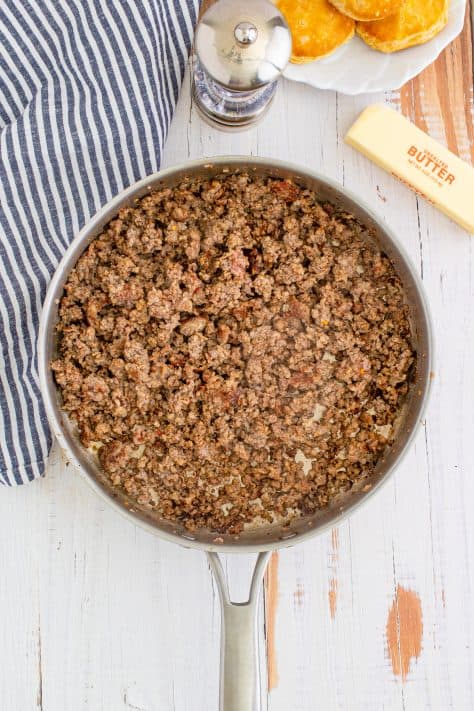 Cooked sausage in metal pan with striped linen