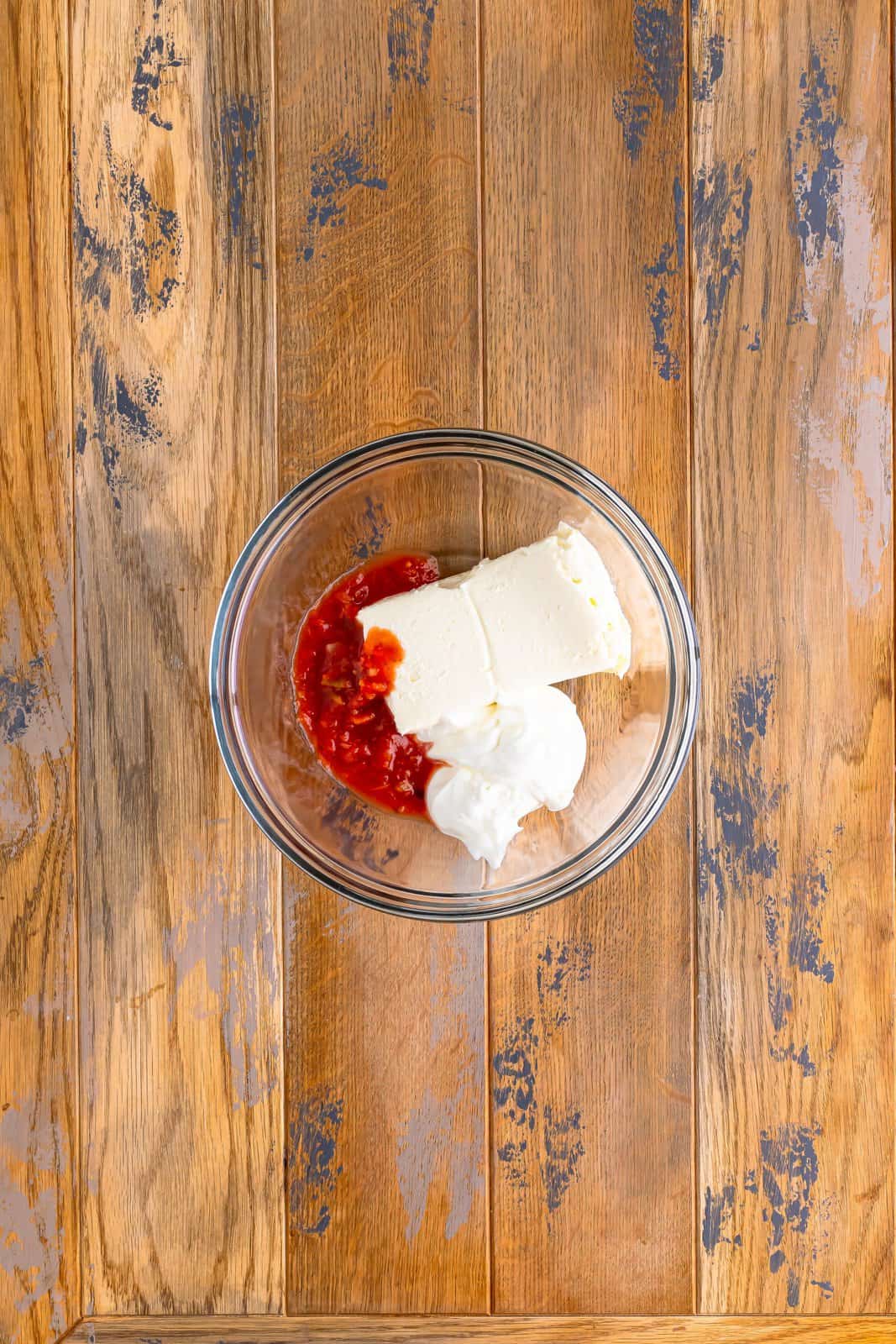 cream cheese, sour cream and salsa in a clear bowl. 