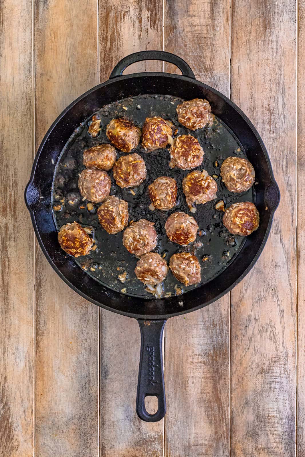 A cast iron skillet with freshly cooked meatballs.