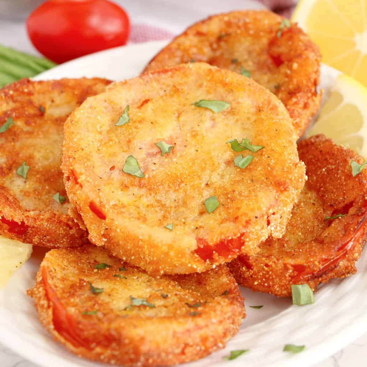 A stack of Fried Red Tomatoes on a plate.