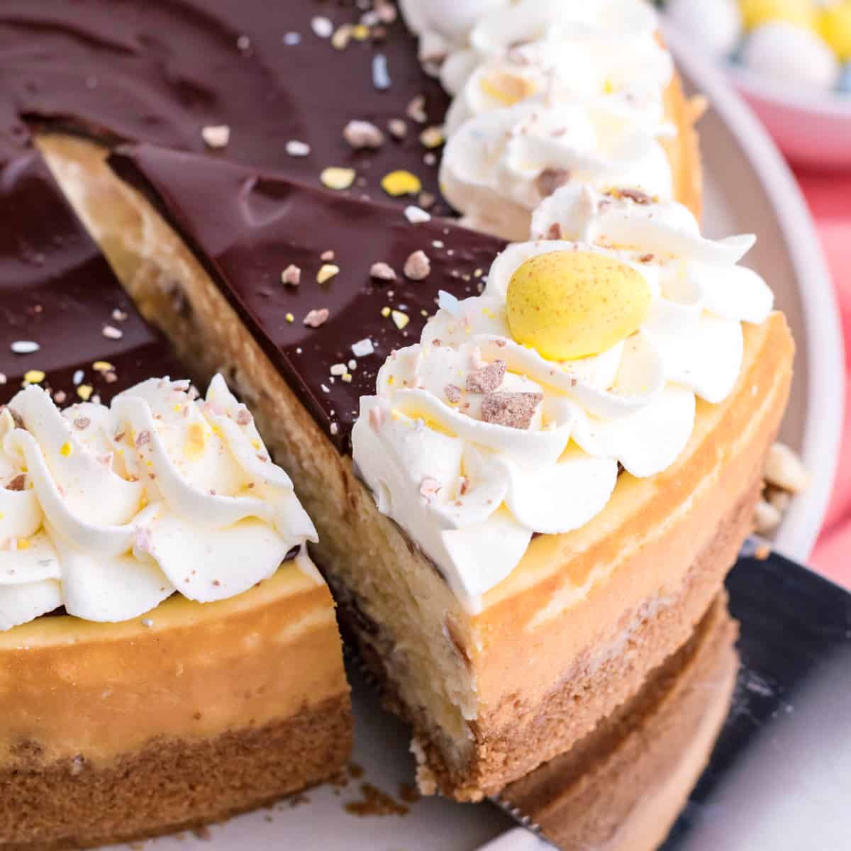 A slice of Cadbury Mini Egg Cheesecake being cut.