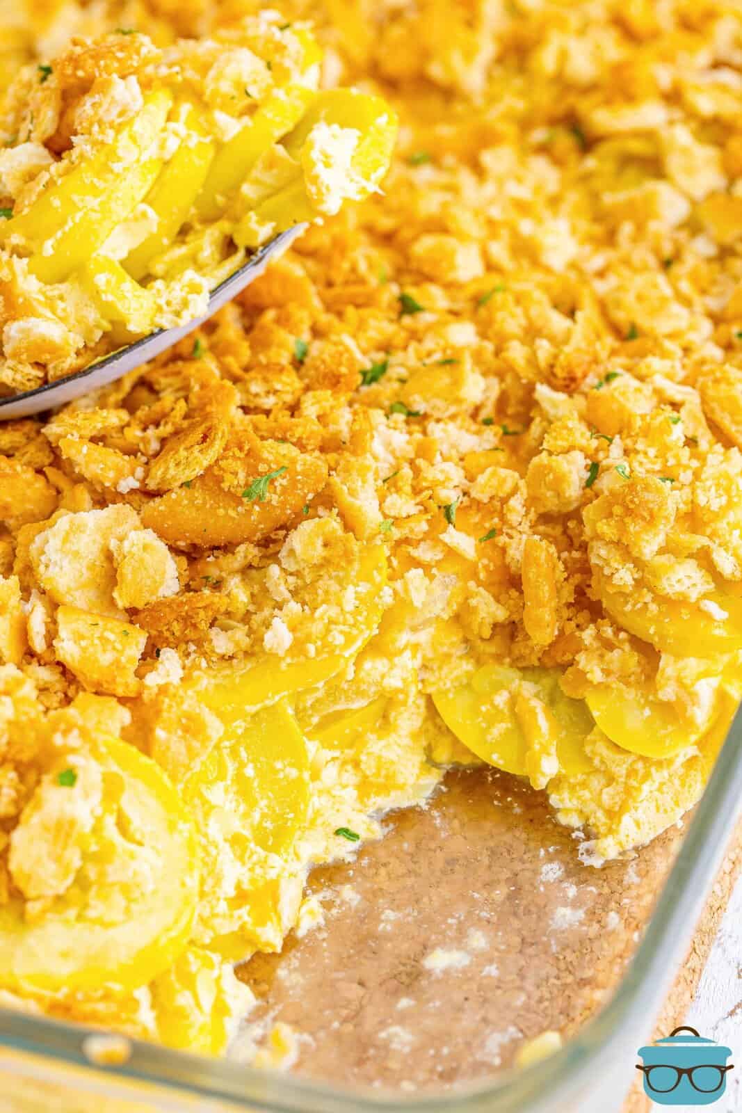 Close up looking at Squash casserole in a baking dish with a serving taken out.