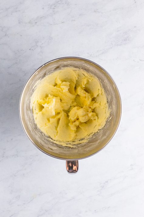 Butter and sugar creamed together in a mixing bowl.